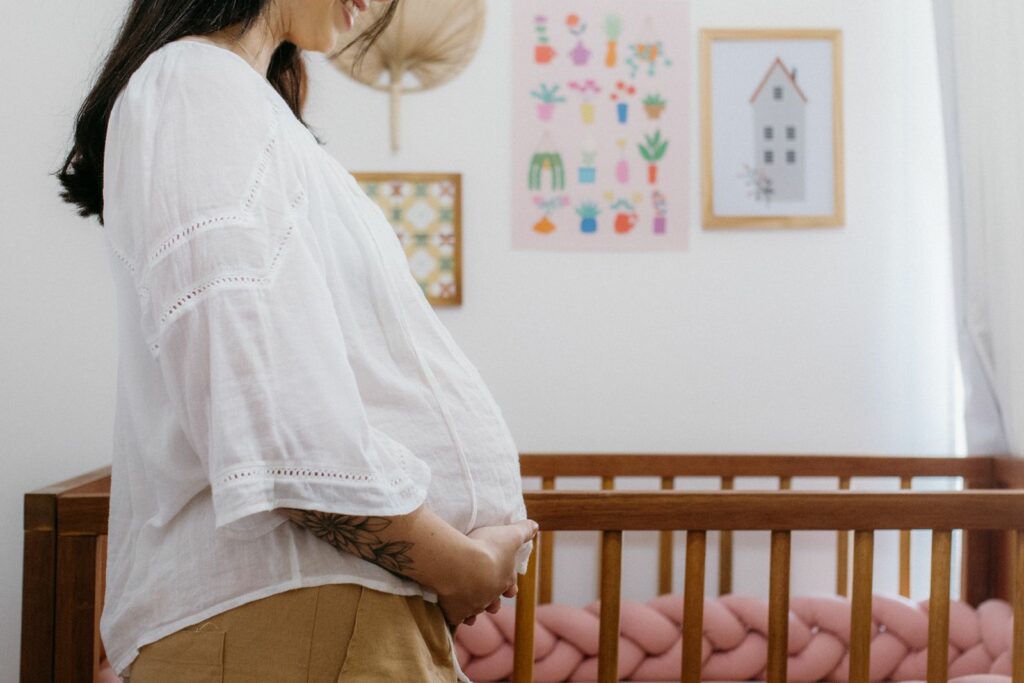 Future maman dans la chambre de bébé