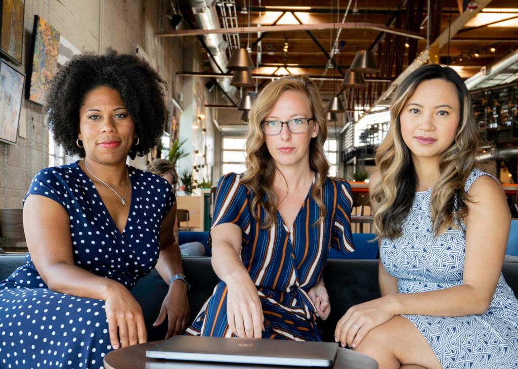 Trois femmes souriantes assises ensemble