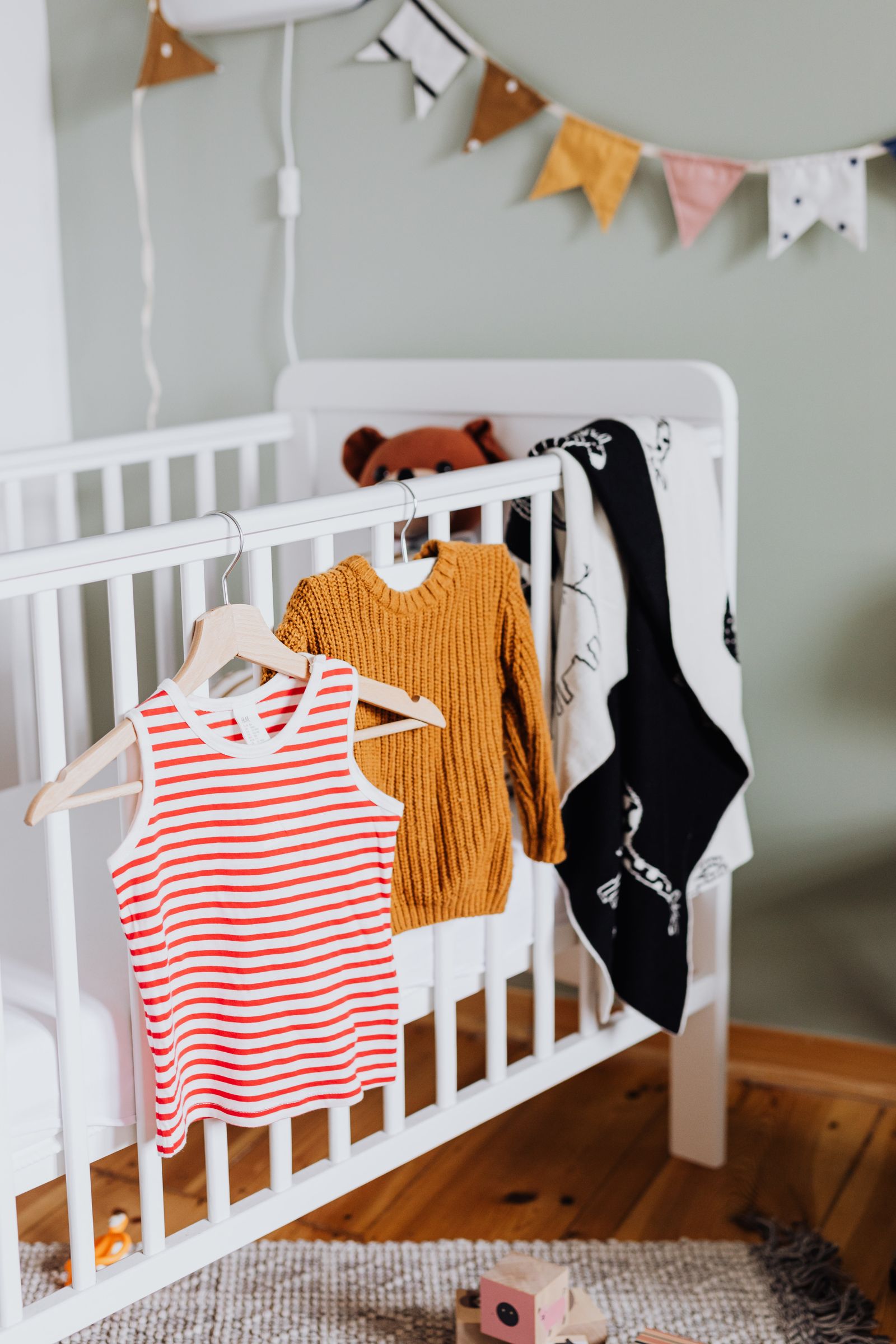 Vêtements de bébé suspendus près du lit